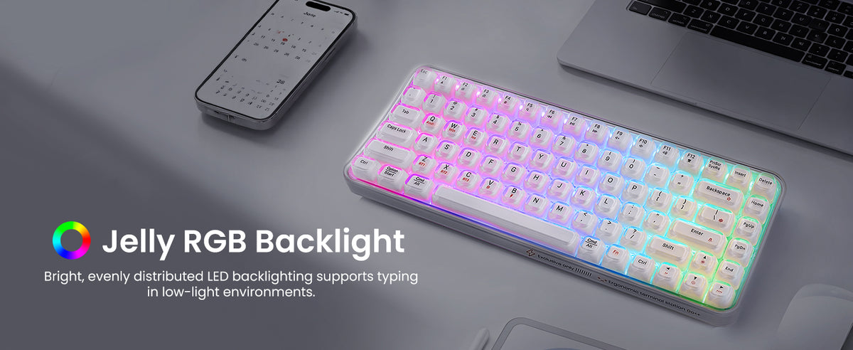Text reads "Jelly RGB Backlight". Pink and purple illuminated RGB mechanical keyboard with backlit keys positioned on dark desk surface next to smartphone and laptop.